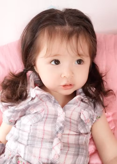 Diện áo kẻ caro, Mộc Trà được mẹ cột tóc hai bên. Tạo hình của cô nhóc được nhiều cư dân mạng nhận xét dễ thương, đáng yêu. Trước đó, bé vốn gắn liền với mái tóc buộc củ tỏi trông cá tính. (Ảnh: Facebook nhân vật) 