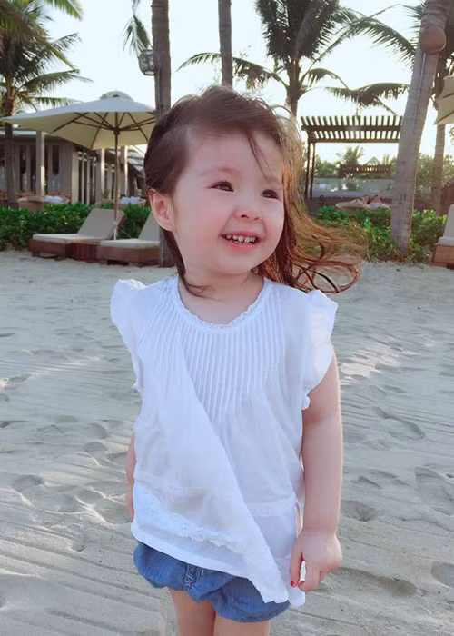 Hình ảnh bé Mộc Trà nhiều lần “gây thương nhớ” cho cư dân mạng. Trong ảnh, nhóc tì nhà hot girl Elly Trần xõa mái tóc màu nâu xoăn tự nhiên tung bay trong gió biển. (Ảnh: Facebook nhân vật) 