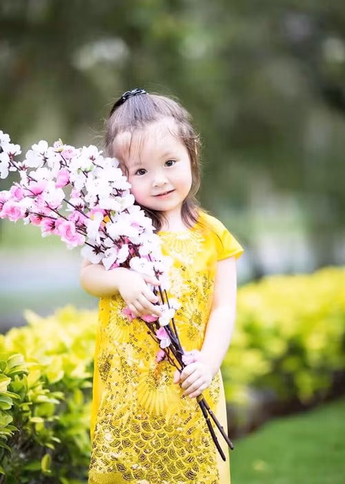 Kể từ khi chào đời cho đến nay, bé Mộc Trà - con gái Elly Trần chưa bao giờ hết hot nhờ vẻ đẹp lai Tây. Khoảnh khắc mặc áo dài ôm cành đào to bự là một trong những bức ảnh hút views nhất của cô nhóc hơn 2 tuổi này. (Ảnh: Facebook nhân vật) 