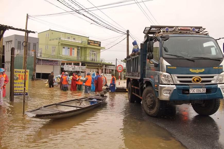 Lực lượng cứu hộ lỗ lực đưa hàng cứu trợ về đồng bào vùng lũ Quảng Bình. Ảnh: TTXVN.
