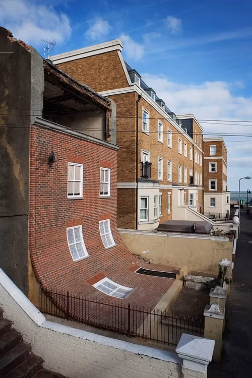 Ngôi nhà ở thị trấn Margate, Anh này hoàn toàn không có gì đáng chú ý, nhưng nghệ sĩ Alex Chinnek đã có một giải pháp tao nhã, biến nó thành một tác phẩm nghệ thuật. Alex sử dụng những tàn tích của ngôi nhà làm căn cứ để khiến cho nó trông giống như mặt tiền của ngôi nhà đã trượt xuống mặt đất. (Nguồn Boredomtherapy)