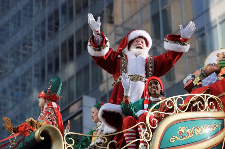 Ông già Noel vui mừng vẫy chào người dân khi cùng đồng nghiệp diễu hành ở New York.