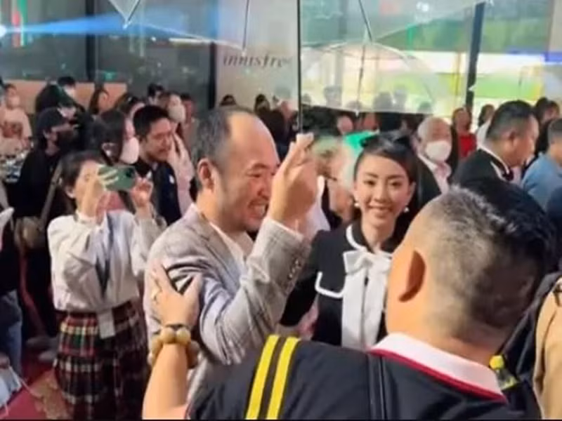 Không những vậy, nam diễn viên hài còn cầm dù che cho bà xã để cô thoải mái trò chuyện cùng đồng nghiệp. Ảnh: Vietnamnet