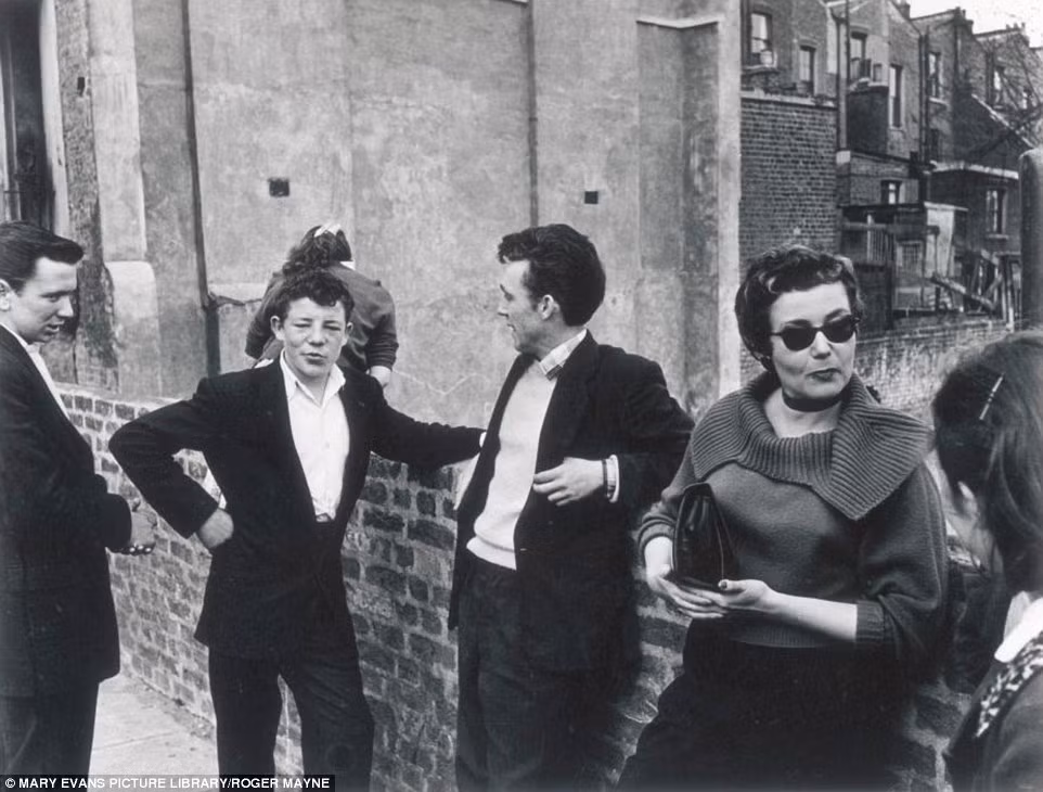 Các thanh niên thuộc tầng lớp lao động đang trò chuyện bên góc đường ở tây London năm 1956. Ảnh Daily Mail