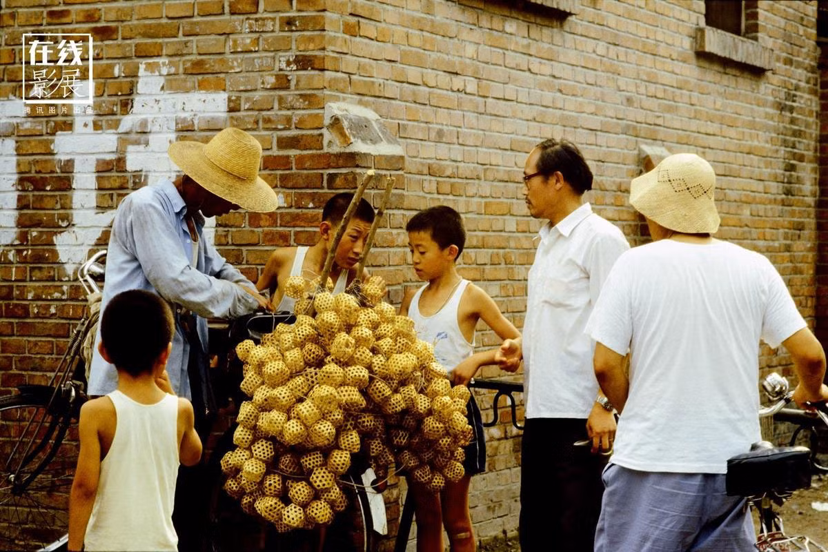 Đám trẻ đến xem và mua những lồng đựng dế được một người bán hàng treo trên xe đạp. Ảnh chụp ở thủ đô Bắc Kinh năm 1970. Ảnh QQ