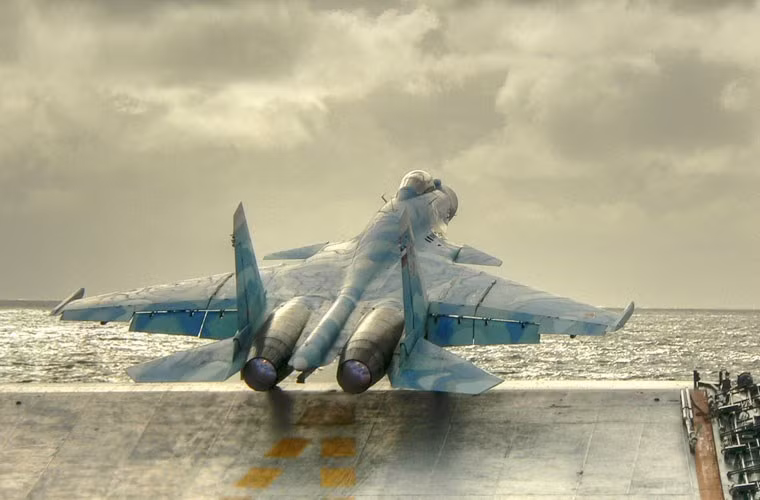 Su-33 là tiêm kích hạm hoạt động trong mọi điều kiện thời tiết do Sukhoi phát triển trên cơ sở nền tảng tiêm kích huyền thoại Su-27. Khoảng 35 chiếc đã được chế tạo để trang bị cho tàu sân bay Kuznetsov, tuy nhiên ít khi con tàu này mang đủ số Su-33 mà nó được dành cho. Ảnh: Su-33 cất cánh bằng boong phóng nhảy cầu từ tàu sân bay Kuznetsov.