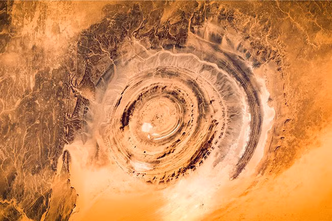 9. Vòng xoáy Richat giống như con mắt trên sa mạc Sahara với đường kính vòng xoáy dài 49km có thể nhìn thấy từ vũ trụ. Đã có nhiều giả thiết về sự hình thành các vòng xoáy kỳ lạ này, nhưng vẫn khó có lời giải thích thỏa đáng cho việc hình thành vòng xoáy đồng tâm hoàn hảo và đều nhau như thế.