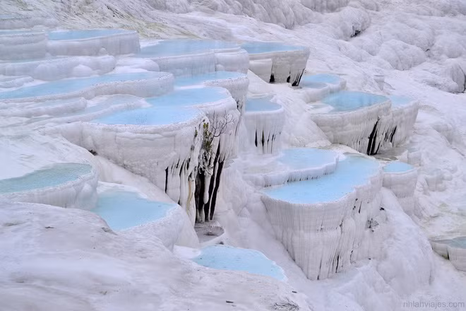 Pamukkale, Denizli, Thổ Nhĩ Kỳ: Trong tiếng Thổ Nhĩ Kỳ, Pamukkale có nghĩa là "lâu đài bông". Như tên gọi, hồ suối khoáng nổi tiếng thế giới này ấn tượng với những bậc thềm trắng xóa, bên trong chứa nước màu xanh ấm áp.