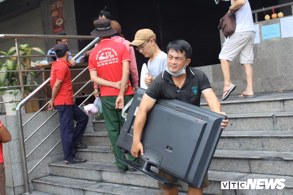 Anh Trần Đức Cường (cư dân chung cư Carina Plaza) cho biết: “Những ngày qua, gia đình tôi huy động thêm anh em đến vận chuyển nhiều đồ đạc trong nhà đến chỗ mới để phục vụ sinh hoạt, đồng thời để chủ đầu tư sửa chữa lại. Sau vụ cháy, nhà tôi chỉ bị khói, vết đen bám vào tường đổi màu chứ không thiệt hại gì cả”. Ảnh: Mồ hôi nhễ nhãi, khuôn mặt mệt mỏi của cư dân chung cư Carina khi chuyển đồ về chỗ ở tạm.