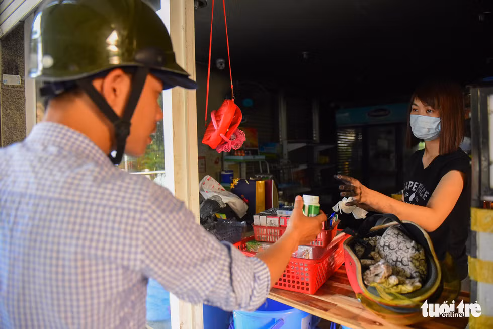 Trong tiệm tạp hóa, hàng hóa bám đầy khói bụi, thế nhưng họ vẫn tranh thủ bán hàng, gỡ được đồng nào hay đồng đó.