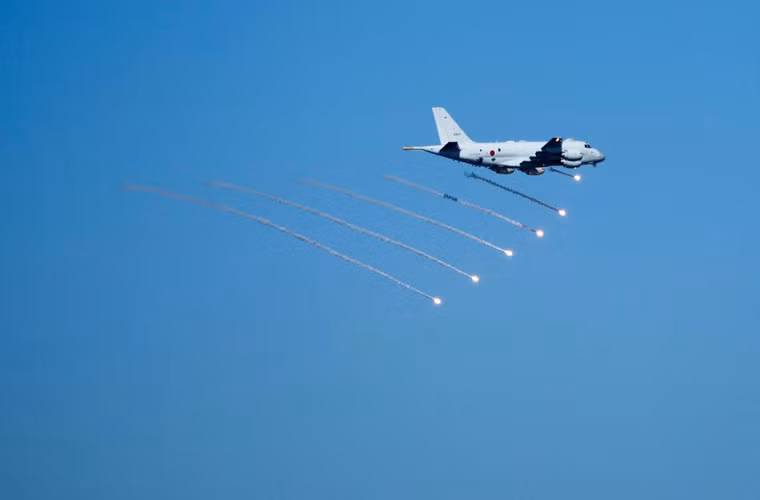 Máy bay săn ngầm Kawasaki P-1 phóng pháo sáng trên bầu trời.