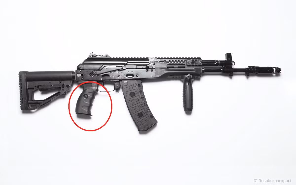 Các dòng súng AK cũ thường có tay cầm khá nhỏ, không được thoải mái cho lắm. Tay cầm AK-12 bằng polymer lớn hơn một chút và cầm có cảm giác chắc tay nhờ các rãnh. Phía trên là cần gạt hạn định bắn, được thiết kế to hơn, giúp người bắn có thể sử dụng dễ dàng, mà không cần rời báng súng.