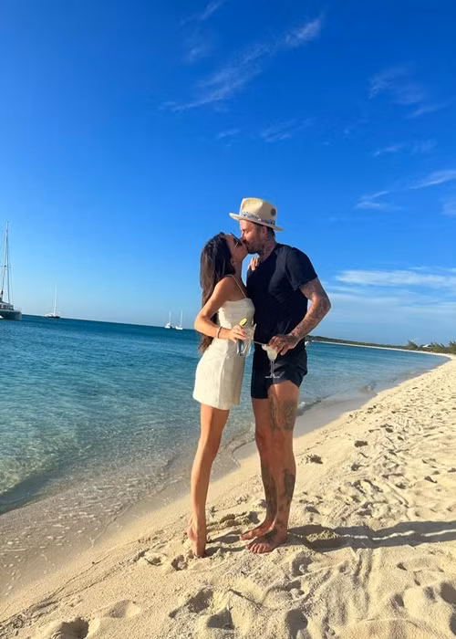Victoria Beckham diện váy hai dây ôm sát cơ thể trong một chuyến đi biển cùng chồng.