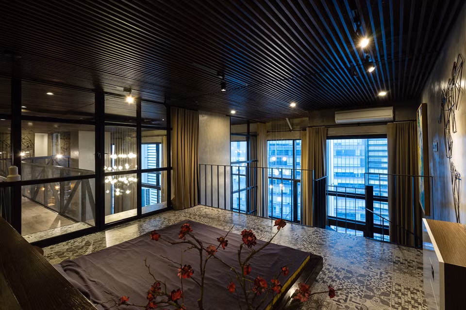 Phòng ngủ lớn với vách kính nhìn sang các khu vực khác của căn hộ, đồng thời có hướng nhìn ra thành phố. Ảnh: Archdaily.