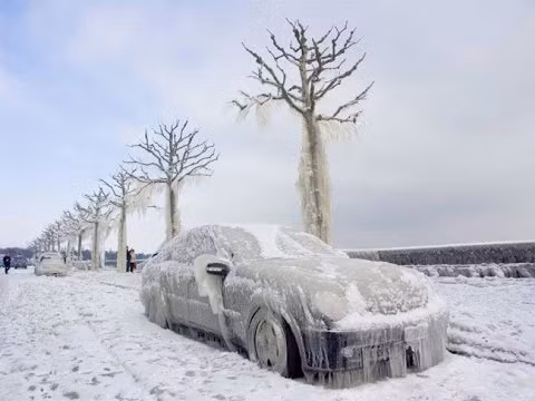 Một chiếc oto bị đóng băng hoàn toàn trên đường phố.
