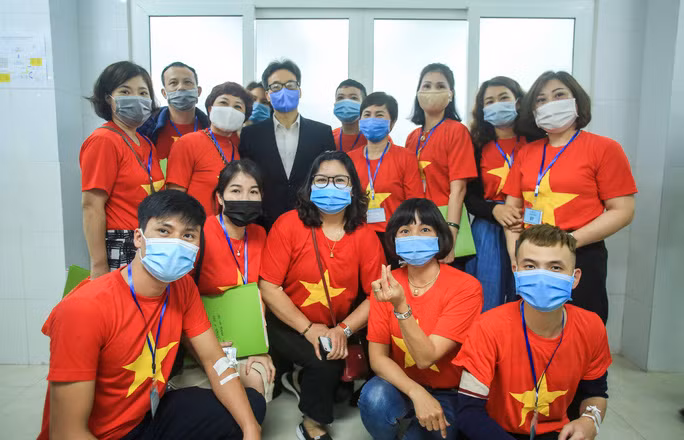 Phó Thủ tướng Vũ Đức Đam chụp ảnh cùng một số tình nguyện vừa tiêm xong vắc-xin phòng COVID-19. (Ảnh: Người lao động)