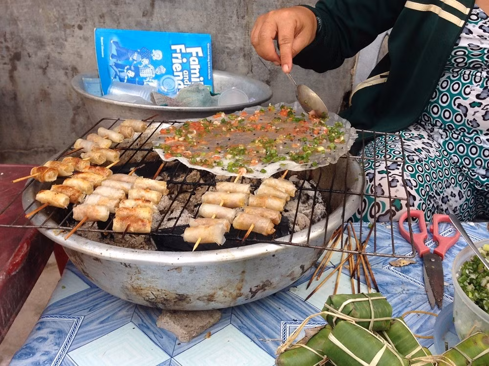 Cả ngày rong chơi đã thấm mệt, bụng đói mèm. Nhìn cách cô bán hàng chế biến bánh tráng mắm ruốc khiến chúng tôi ứa nước miếng, nhấp nhổm không yên. Trên một chiếc bếp than nhỏ bằng chậu nhôm, cô đặt chiếc bánh tráng mỏng, thêm lớp hành lá cắt nhỏ, chút mắm ruốc và tán đều ra hết mặt bánh. Nhiệt độ từ than tỏa ra làm bánh tráng nóng giòn và rực thơm mùi mắm ruốc quá đỗi hấp dẫn. Bánh tráng mắm ruốc là món nhất định phải ăn khi bạn tới hòn đảo Robinson này.