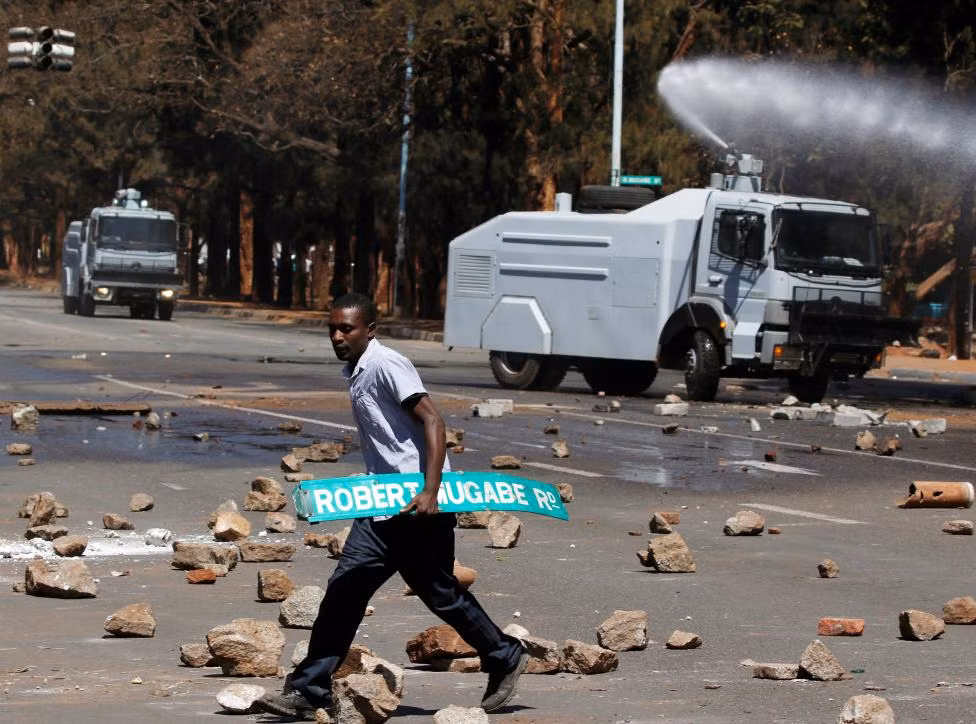 Người đàn ông đi qua con đường đầy gạch đá ở Harare.