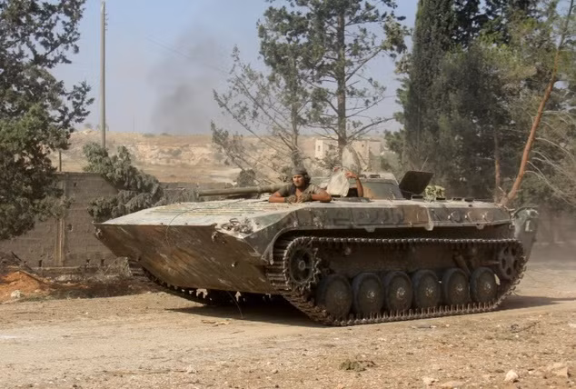 Các chiến binh Feteh al-Sham Front lái xe tăng trên đường sau khi chiếm giữ một số căn cứ quan trọng ở phía nam Aleppo hôm 6/8.