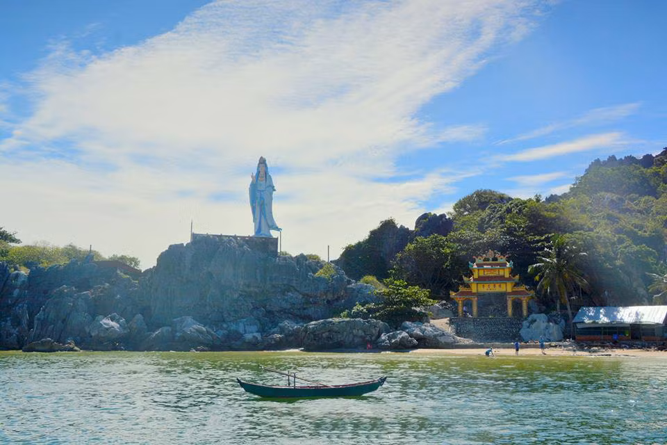 Đến Hòn Nghệ, bạn nên ghé núi Lầu Chuông để chiêm ngưỡng tượng Phật Bà khổng lồ. Tượng Phật Bà cao 20 m đứng uy nghi, tự tại giữa lưng chừng núi Lầu Chuông. Đây là ngọn núi đá vôi bị xâm thực nên có hình dáng đẹp, kỳ vĩ với hệ thống hang động bí hiểm. Ảnh: Camnhung.
