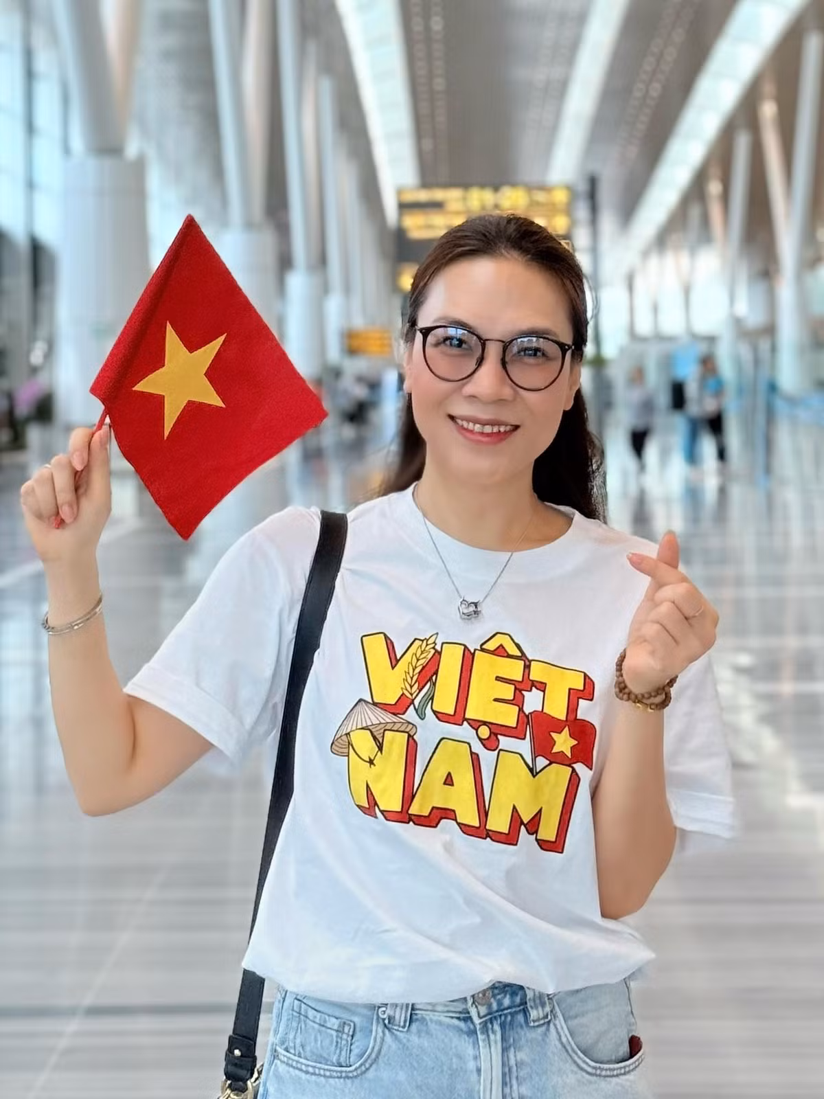 Ca sĩ Mỹ Tâm thể hiện niềm tự hào dân tộc khi mặc áo in hai chữ "Việt Nam" và cầm theo cờ Tổ quốc. Ảnh: FB My Tam