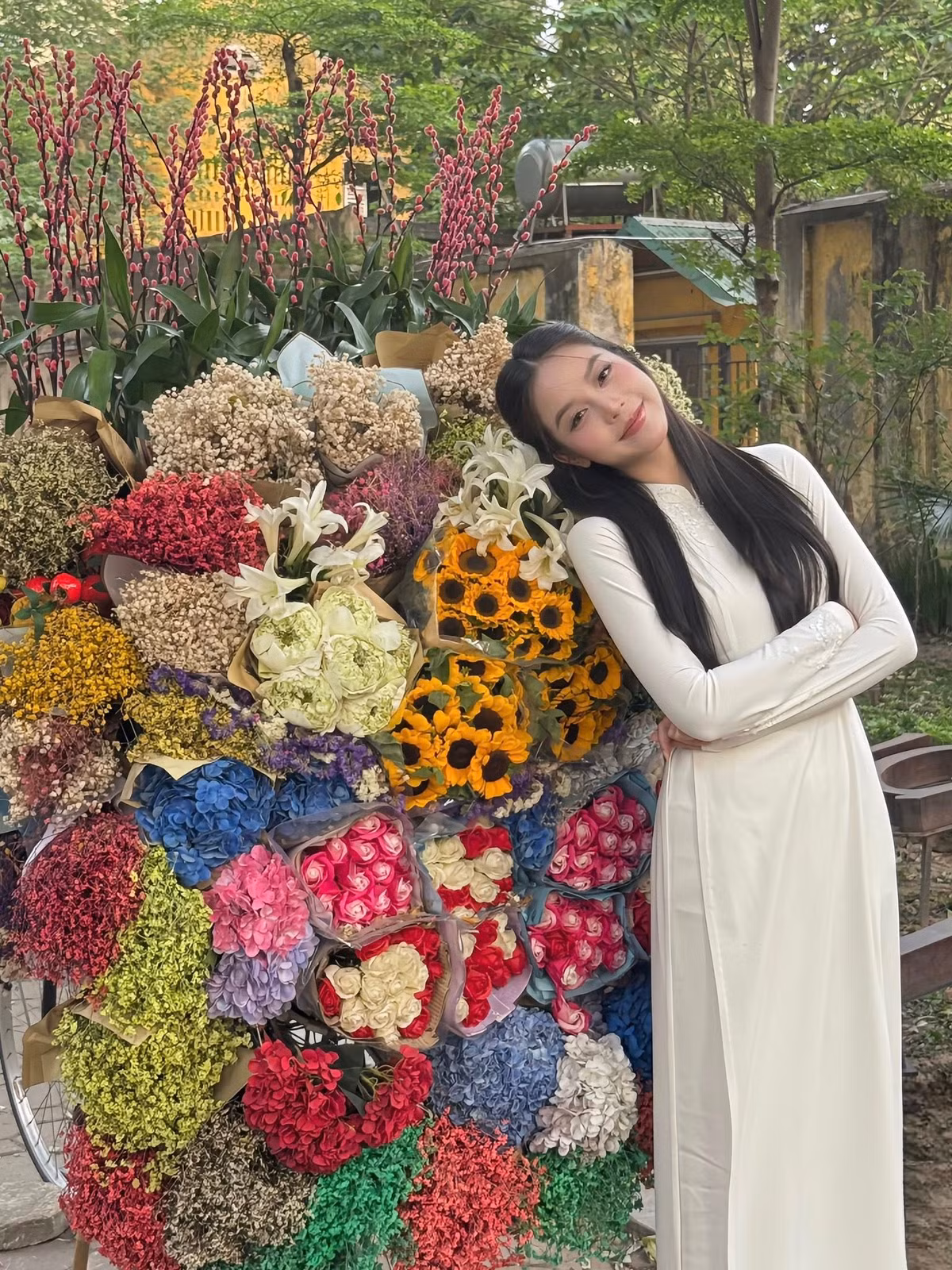 Hoa hậu Thanh Thuỷ mặc áo dài trắng chụp bên xe hoa. Ảnh: FB Huỳnh Thị Thanh Thủy