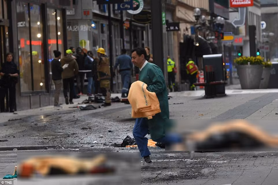 Nhân viên y tế phủ những tấm chăn màu da cam lên các thi thể bên ngoài trung tâm Ahlens ở Klarabergsgatan. Ảnh: Daily Mail.