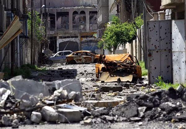 Một con đường ngổn ngang gạch vỡ và những chiếc ô tô bị hư hại ở thành phố Mosul. Ảnh: FNA.