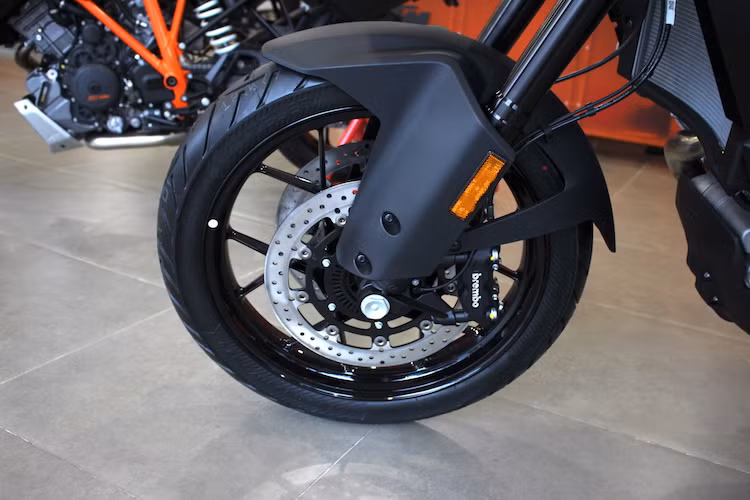 Dù có giá rẻ hơn nhưng KTM 1050 Adventure vẫn sở hữu khá nhiều phụ tùng "hàng hiệu" như phanh Brembo, phuộc USD Ohlins. Thay vì sử dụng vành nan như nhiều mẫu adventure cao cấp, xe được trang bị cặp mâm đúc 6 cánh kép, với mâm trước đường kính 19 inch và cỡ lốp 110/80. Lốp xe là loại Tourance do thương hiệu Đức Metzeler sản xuất.
