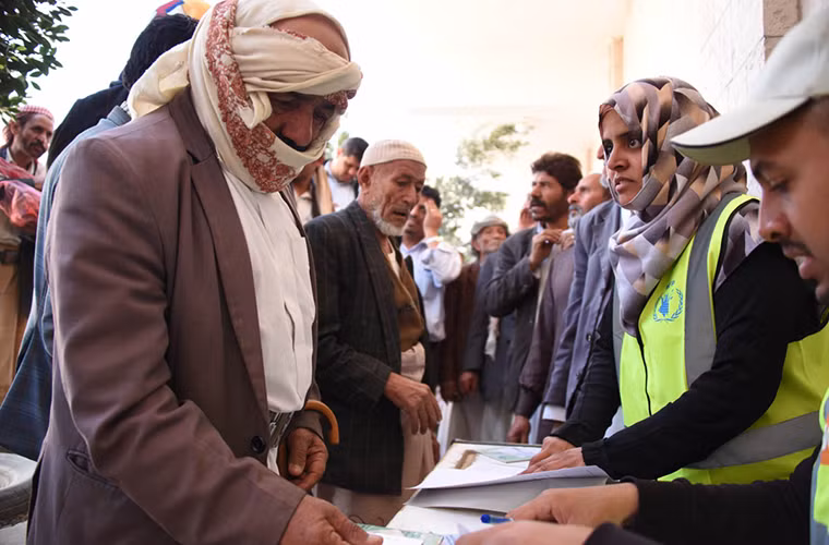 Người dân Yemen xếp hàng nhận phiếu phân phát thực phẩm ở Sanaa. Được biết, 8,6 triệu người Yemen hiện sắp chết đói sau các cuộc giao tranh tại quốc gia Trung Đông này suốt 1.000 ngày qua cùng với việc nguồn thực phẩm, nhiên liệu và thuốc men bị phong tỏa. Ảnh: AJ.