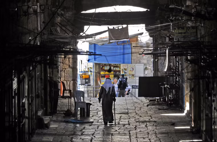 Người đàn ông Palestine lớn tuổi đi bộ trong Thành phố cổ Jerusalem ngày 28/7/2017, vài tháng trước khi "giông bão" ập tới. Ảnh: Sputnik.