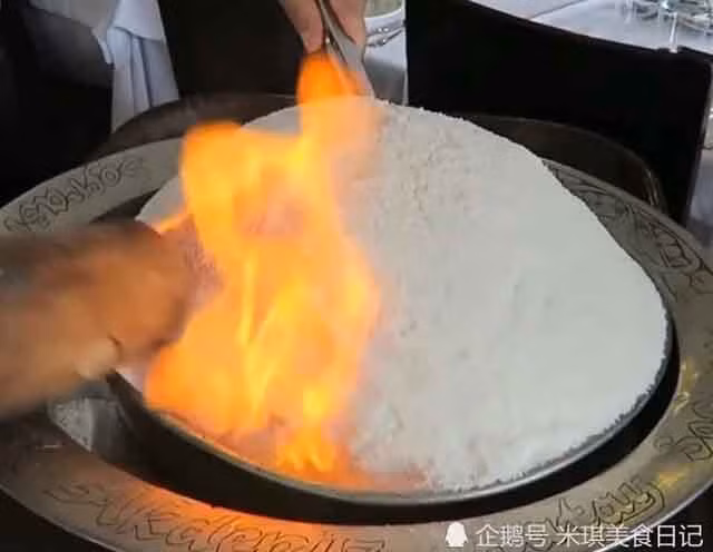 Ban đầu, người đầu bếp châm lửa đốt lên một tảng đá trắng đến mức cháy xém, rồi sau đó dùng búa đập vỡ, từng mảnh vụn rơi ra, dày như miếng gạch để lộ ra bên trong là một con gà được tẩm ướp đầy đủ gia vị và thảo dược.