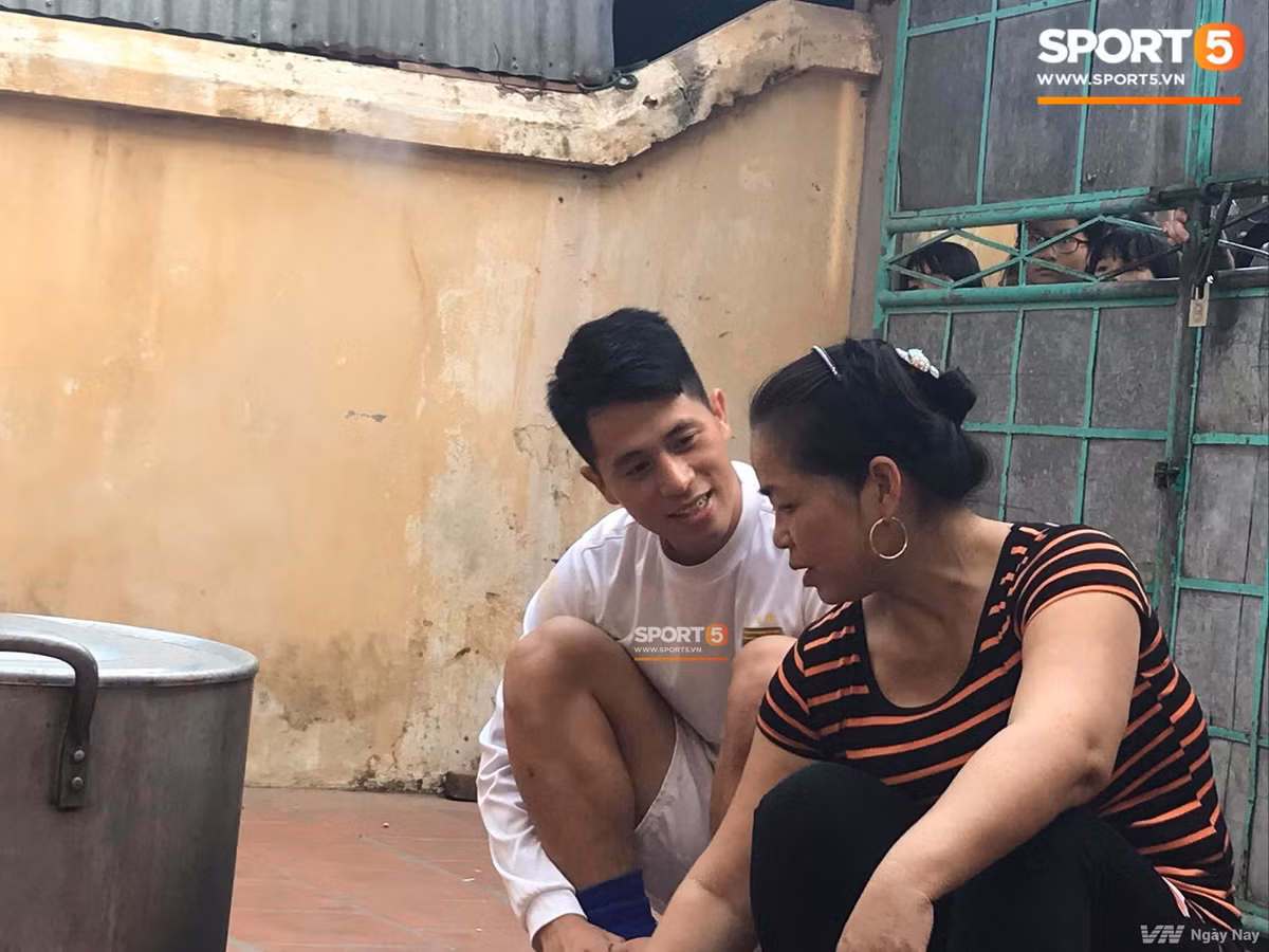 Trong khi đó, Đình Trọng ngồi bên bếp bánh chưng của mẹ Duy Mạnh để hỏi thăm và lắng nghe những chia sẻ trong cuộc sống. Ảnh: Sport5.
