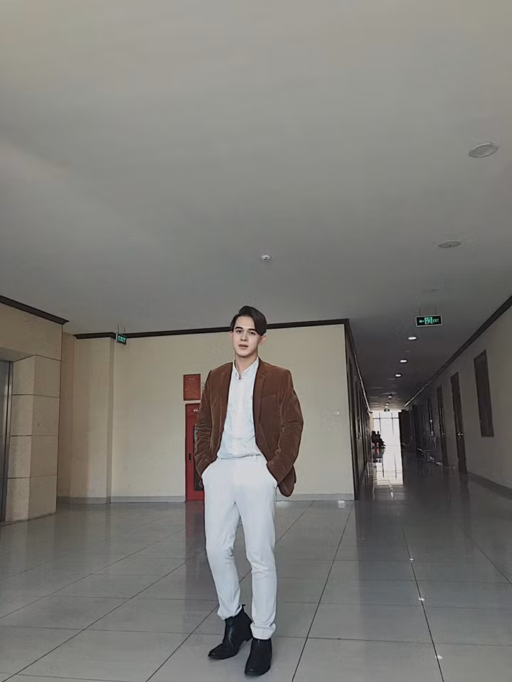 Anh chàng trông càng điển trai hơn khi diện cả cây trắng phối với áo vest nâu.