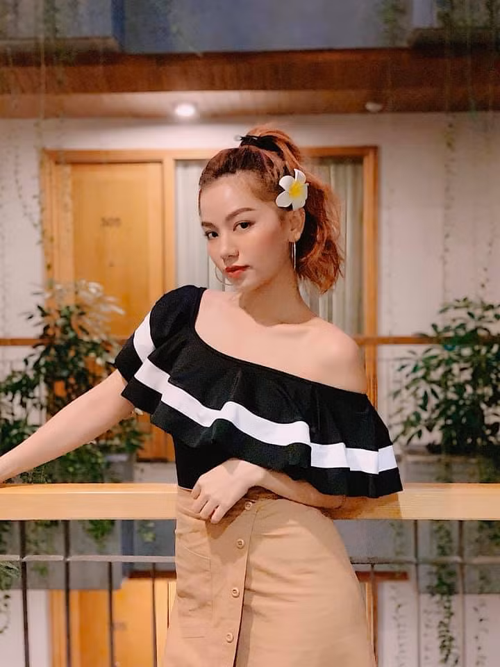 Chiếc áo trễ vai bánh bèo được Hạ Anh phối với chân váy hiện đại, thời thượng.