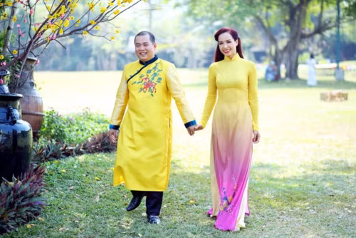 Vợ chồng Minh Khang - Thúy Hạnh diện áo dài gam vàng nổi bật.