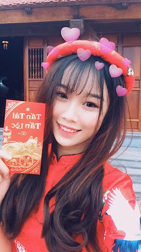 Trang Nhung, bạn gái cầu thủ Văn Toàn, cũng diện áo dài đỏ du xuân cầu mong may mắn ngày đầu năm.