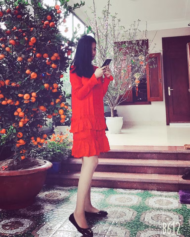 Dương Thị Thùy Phương, vợ trung vệ Quế Ngọc Hải diện váy đỏ rực rỡ đi chúc tết đầu năm.