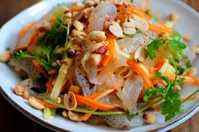 Ngoài ra, người dân nơi đây còn phi hành với dầu ăn dậy mùi thơm, vàng rộm trộn đều nhau, rồi rưới nước mắm và nêm nếm món gỏi cho thật vừa khẩu vị, và rắc thêm đậu phộng. Ảnh: Du lịch VN.