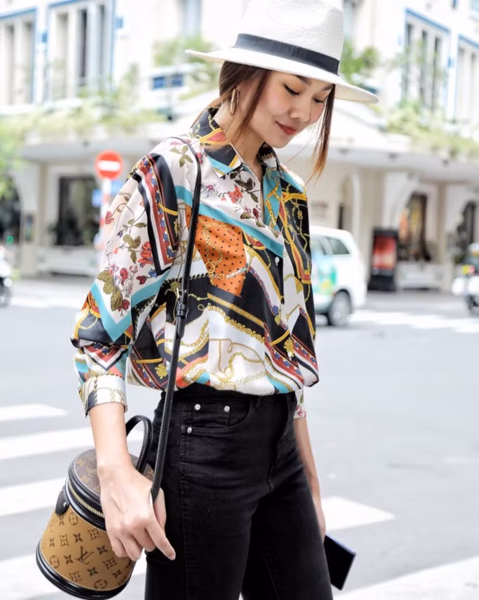 Thanh Hằng trông rất phong cách khi thả dáng trên phố cùng set đồ áo sơ mi họa tiết, quần jean, mũ cói và chiếc túi hàng hiệu.