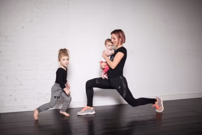 Lunges bước lên: Vẫn giữ em bé trước mặt, hai chân đứng thẳng, rộng bằng một vai. Bước một bước dài lên phía trước, hạ thấp trọng tâm sao cho đầu gối vuông góc. Giữ trong vài giây rồi trở về tư thế chuẩn bị. Lặp lại động tác 10 lần rồi đổi bên.