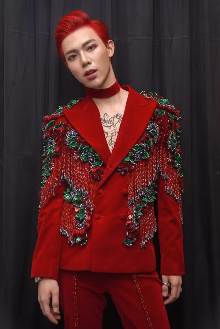 Chiếc áo vest đỏ được đính kết đầy cầu kì ton sur ton với mái tóc nhuộm và vòng choker.