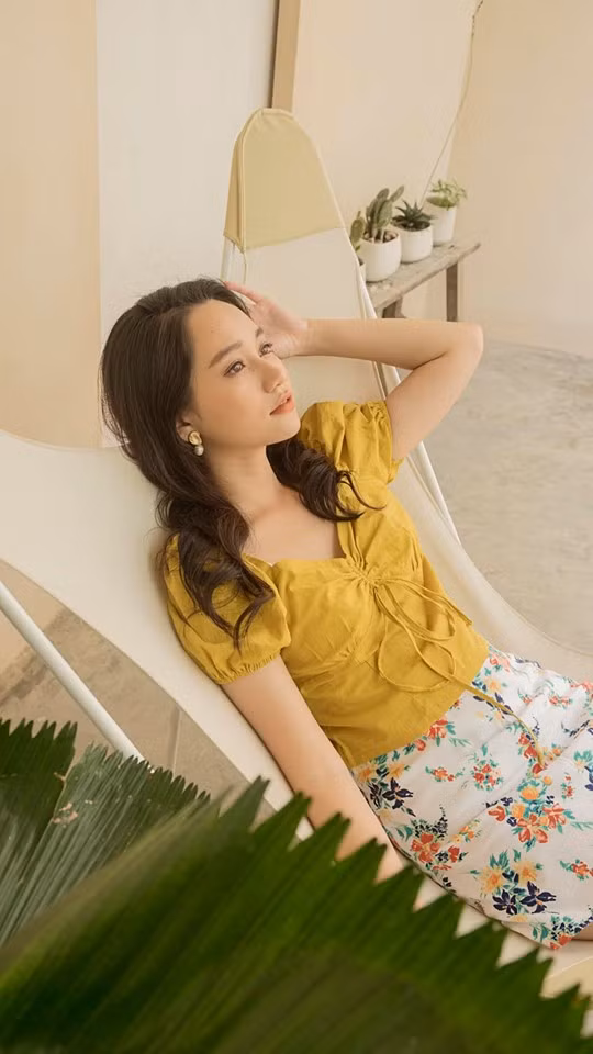 Cô phối váy hoa với áo vàng nổi bật.