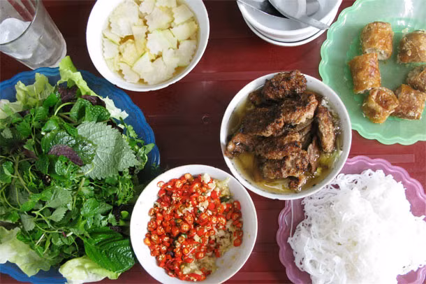 Bún chả được du khách nước ngoài xếp hạng là “món ăn hấp dẫn nhất Hà Nội mọi thời đại”. Bún gạo được cắt ra đĩa, chấm vào bát nước mắm pha sẵn với thịt lợn ba chỉ và chả viên nướng. Việc pha thêm các gia vị như tỏi băm, quất, ớt, dấm tỏi,... vào bát nước chấm sẽ khiến món ăn này “bùng nổ” vị giác và khiến du khách vô cùng thích thú. Ảnh: Seriouseats.
