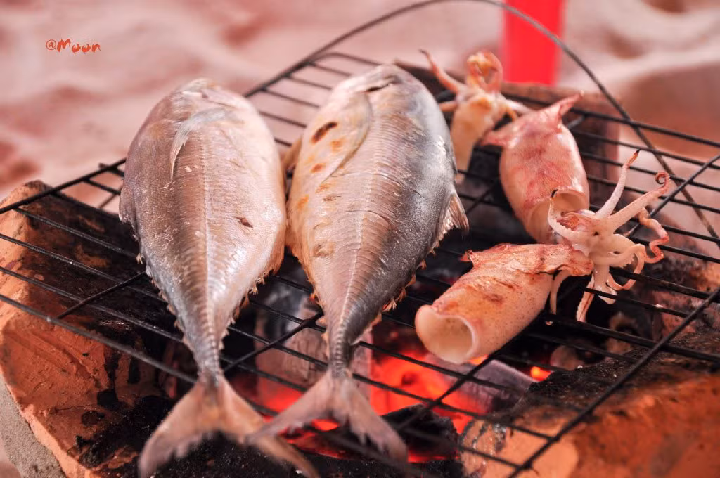 Cá thu nướng: Thịt cá thu nướng được cuộn trong lớp bánh tráng với các loại rau thơm. Chấm nó vào muối tiêu trộn với nước cốt chanh, bạn có thể cảm thấy “thỏa mãn” trong mọi giác quan. Nhấp một ngụm rượu sim địa phương, thêm một ít rau và lát cá tạo nên cảm giác vô cùng tuyệt vời. Ảnh: Livingnomads, Saigontourism.