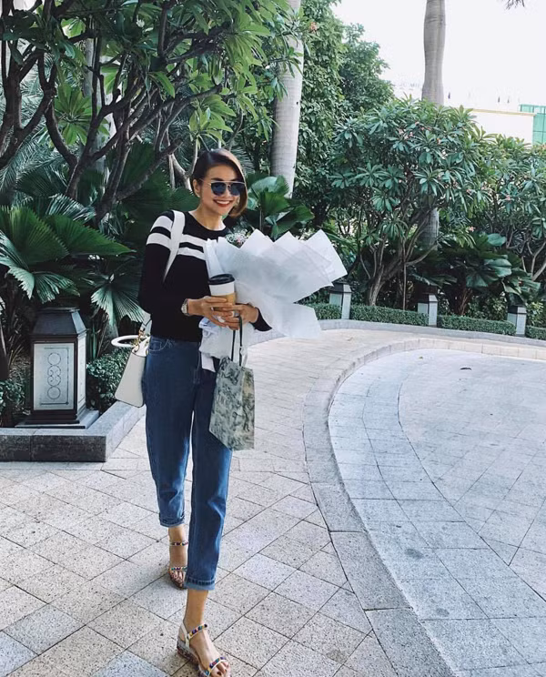 Siêu mẫu Thanh Hằng trông rất phong cách với quần jeans ống côn, áo sweater phối cùng sandal đế xuồng.