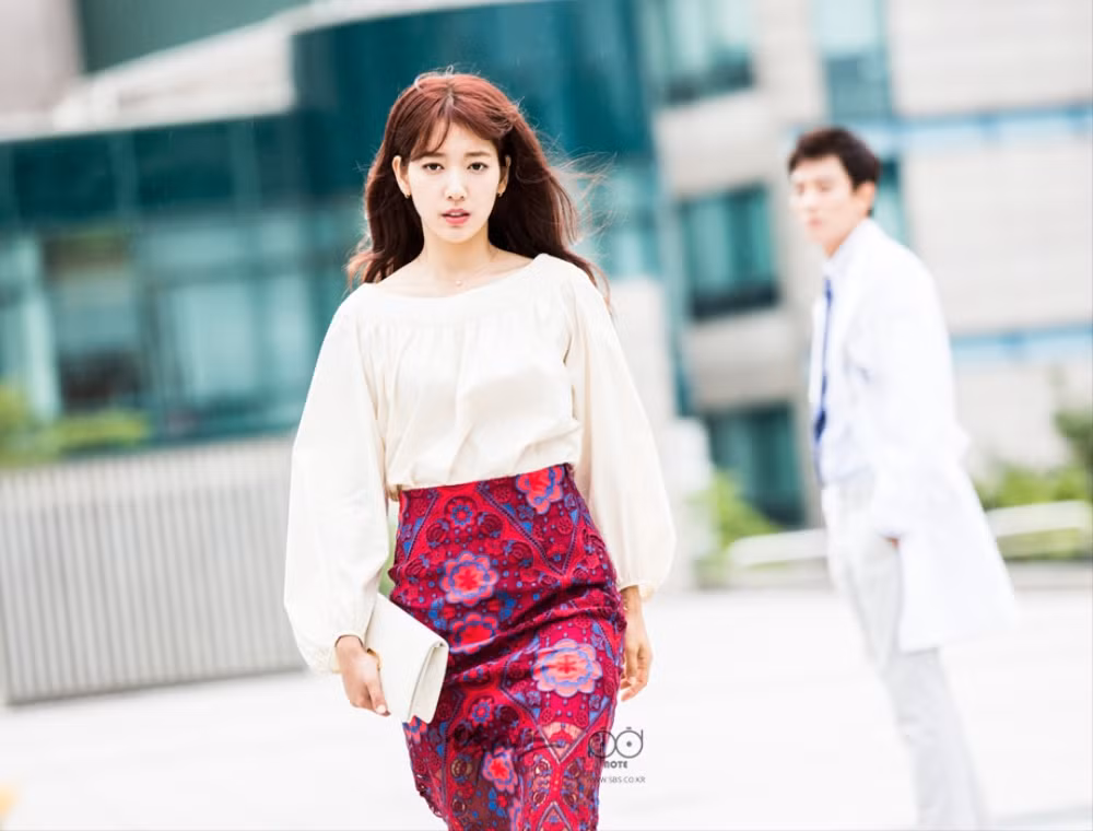 Cô phối áo sơ mi trắng với váy hoa văn đỏ cực kỳ sang chảnh và nổi bật.