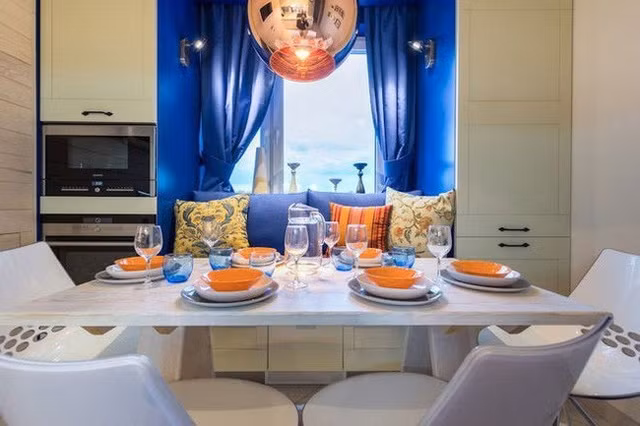 Bàn ăn với thiết kế hiện đại với tông màu trắng. Bàn ăn tuy không lớn nhưng cách thiết kế làm cho không gian bày bàn ăn khá rộng, vừa đủ để cho cả một gia đình cùng ăn tối bên nhau.