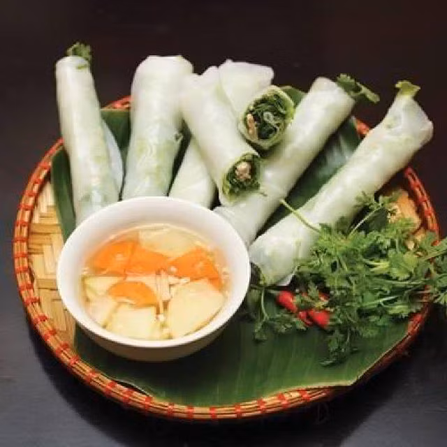 Phở cuốn thường chấm với nước mắm giấm ớt chua ngọt kèm vài lát đu đủ xanh. Vị ngọt bùi của thịt bò xào và phở cộng chút mằn mặn của nước chấm càng thăng hoa hơn với mùi thơm của thịt bò lăn và mùi thơm thanh mát của các loại rau thơm. Ảnh: Foody.