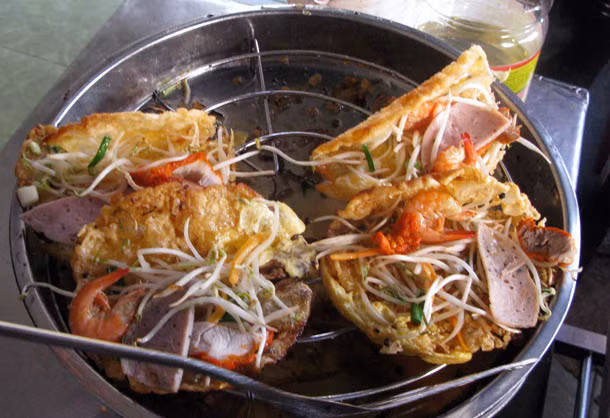 Bánh khoái: Vỏ bánh màu vàng chiên giòn được làm từ bột gạo và trứng, được gấp xung quanh lát thịt lợn nướng, xúc xích và tôm, sau đó phủ lên trên rau củ muối và giá đỗ tươi.